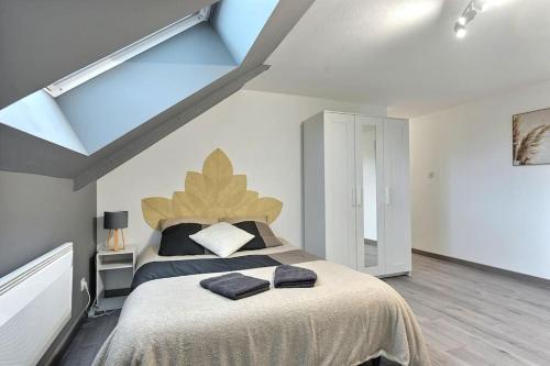 une chambre avec un lit avec deux serviettes dessus dans l'établissement Élégance Urbaine, à Belfort