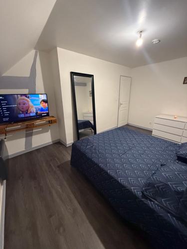 une chambre avec un lit et une télévision à écran plat dans l'établissement Style & Confort, à Sainte-Savine