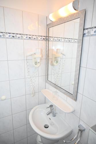 a white bathroom with a sink and a mirror at Einzelzimmer-17-UG in Borkum