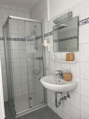 a bathroom with a shower and a sink and a mirror at Budget-Einzelzimmer-06-EG in Borkum
