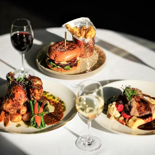 two plates of food on a table with wine glasses at Shoreline Hotel in Donabate