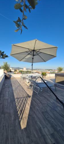 a table and chair with an umbrella on a deck at Zadar Sunset Penthouse with spectacular view and jacuzzi in Zadar