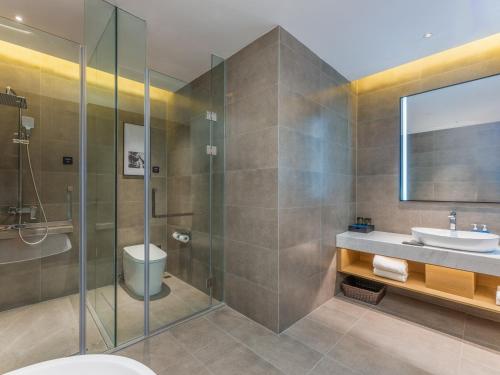 ein Badezimmer mit Waschbecken und Dusche in der Unterkunft Park Inn by Radisson Nanjing North Zhongshan Road in Nanjing