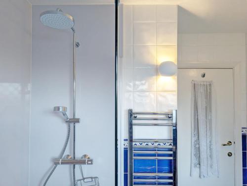 a shower in a bathroom with blue and white tiles at Warner Wood - Selsey in Selsey
