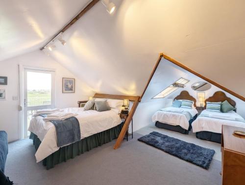 een slaapkamer met twee bedden en een spiegel bij Warner Wood - Selsey in Selsey