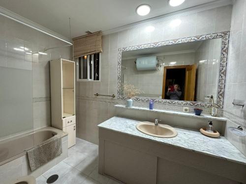 ein Badezimmer mit Waschbecken und Spiegel in der Unterkunft Precioso chalet próximo a Sevilla con jardín y piscina privada 8 personas Wifi gratis 2 salones 4 dormitorios 2 baños in Consolación