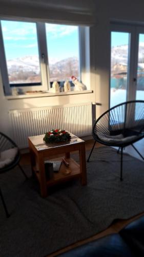 a living room with a table and two chairs and a window at DOM HILLS Bucovina in Gura Humorului