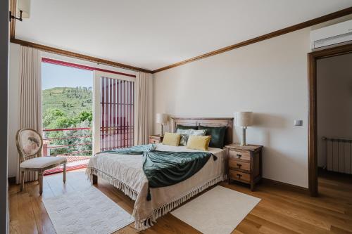 a bedroom with a bed and a large window at Casa Zé Manel - Turismo Rural in Paranhos