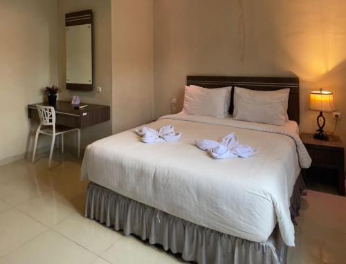 a bedroom with a bed with two towels on it at A'rabia Style Homy Murni in Sunggal