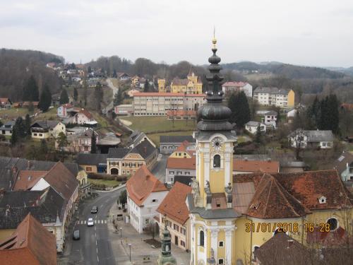 a church with a clock tower in a town at Villa zur Schmied'n in Ehrenhausen