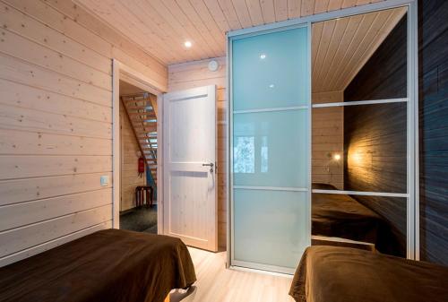 a bedroom with two beds and a glass door at Rukankarhu Apartment in Ruka