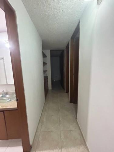 a hallway of a bathroom with a sink and a mirror at Bonito apartamento 3 habitaciones, 4 camas in Cúcuta