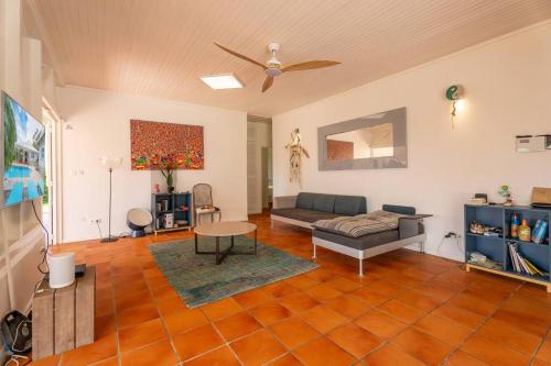 a living room with a couch and a table at Villa Blue Rock, piscine & vue imprenable in Rivière-Salée