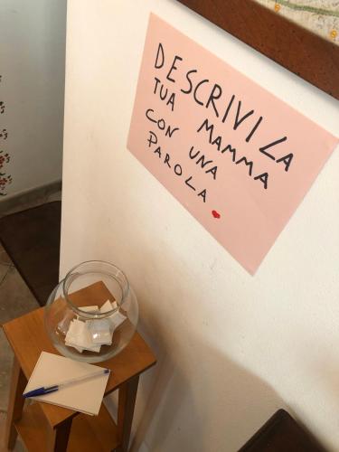 a sign on a wall next to a table with a glass bowl at B&B Casa Mila' in Pretoro