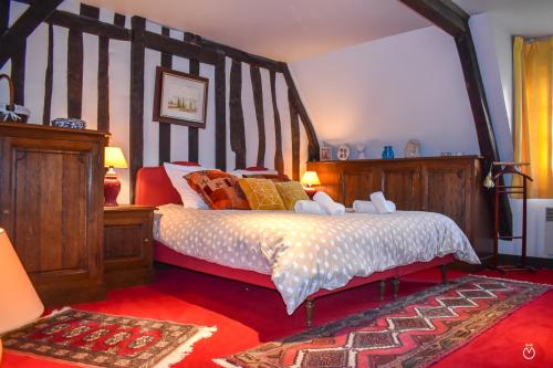 une chambre avec un grand lit avec une tête de lit en bois dans l'établissement La Closeraie - 10 min d'Honfleur-Deauville 7P, à Saint-Gatien-des-Bois