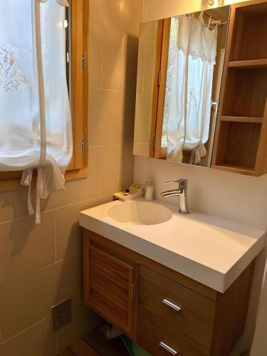une salle de bain avec un lavabo et un miroir dans l'établissement Les Chalets de Megève, confort et tranquillité, à Megève