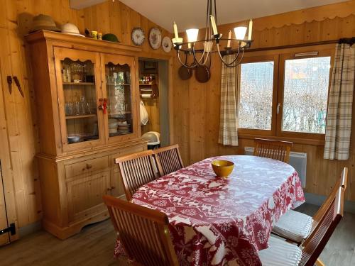 une salle à manger avec une table, des chaises et un lustre dans l'établissement Les Chalets de Megève, confort et tranquillité, à Megève
