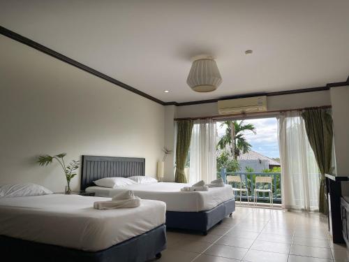 a hotel room with three beds and a balcony at Ben's House in Ao Nang Beach