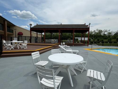 a patio with a table and chairs next to a pool at Suburban Studios Mason Near Kings Island in Mason