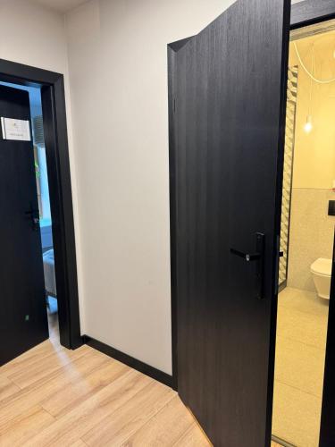 a black door in a room with a toilet at Klimatyczne pokoje na Ligonia in Turza Śląska