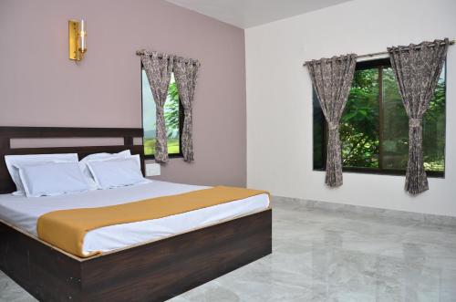 ロナバラにあるRoyal Escape Lonavla - 4BHK Private Pool Villaの窓が2つある寝室のベッド