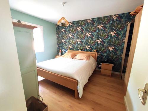 une chambre avec un lit avec un papier peint fleuri dans l'établissement Villa Carline, à Balaruc-les-Bains