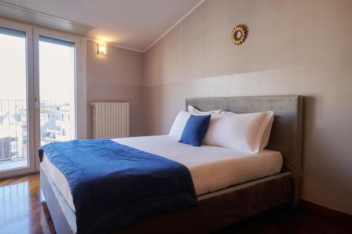 a bedroom with a bed with blue and white pillows at Milan Retreats in Milan