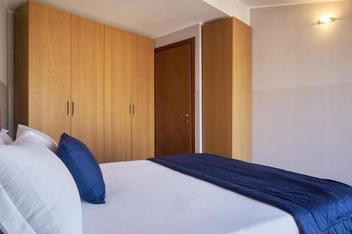 a bedroom with a large white bed with blue pillows at Milan Retreats in Milan