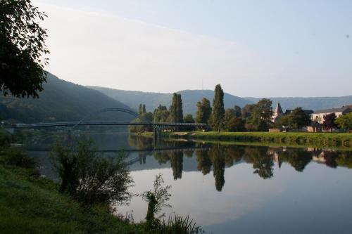 a river with a bridge and trees and a mountain at Chateau de l Aviette - Rancennes in Givet