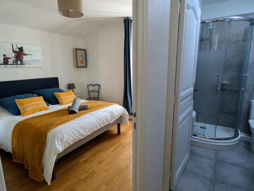 a bedroom with a bed and a glass shower at Maison typique, centre-ville, jardin ville haute in Pornic