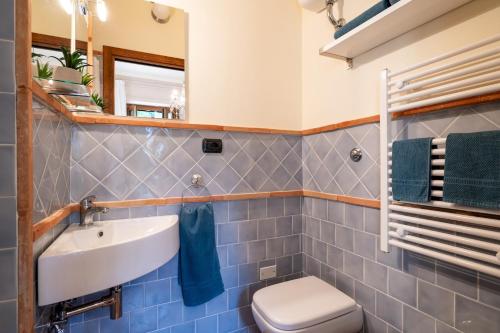 a bathroom with a sink and a toilet and a mirror at VILLA CHERUBINI 8&1, Emma Villas in Cingoli