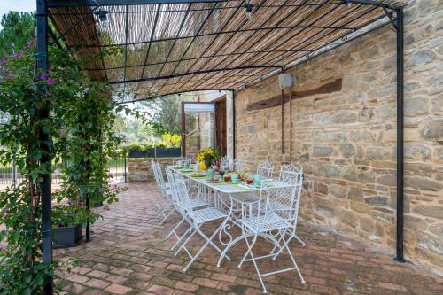 a patio with a table and chairs under a pergola at VILLA CHERUBINI 8&1, Emma Villas in Cingoli
