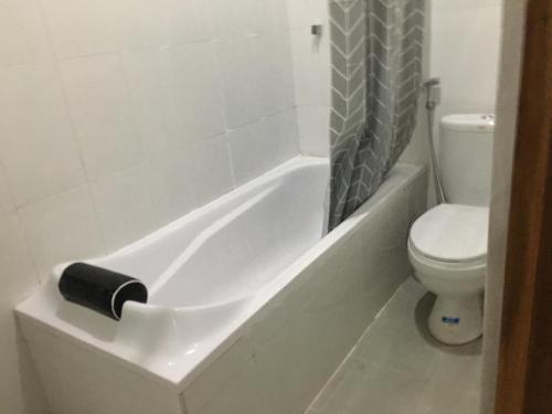 a bathroom with a toilet and a tub with a toilet paper holder at 3 Bedroom Fully Furnished LC Home in Singaraja
