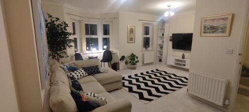 a living room with a couch and a tv at The Parkview House in Wakefield
