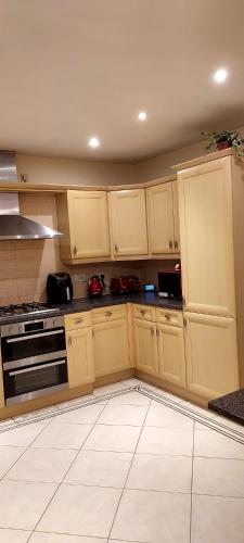 a kitchen with yellow cabinets and a stove at The Parkview House in Wakefield