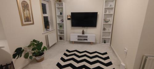 a living room with a flat screen tv on a wall at The Parkview House in Wakefield