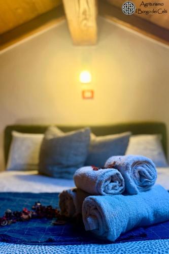 a pile of towels sitting on top of a bed at Il Borgo Dei Celti in Fiumalbo