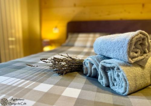 a pile of towels sitting on top of a bed at Il Borgo Dei Celti in Fiumalbo