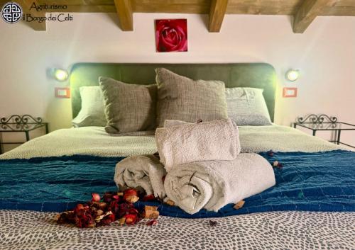 a bed with towels and a pile of roses on it at Il Borgo Dei Celti in Fiumalbo