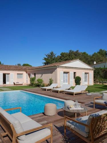 une piscine avec des chaises longues et une maison dans l'établissement Cannes superbe villa rénové, au Cannet