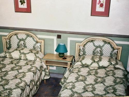 a bedroom with two beds and a table with a lamp at Chateau appartement tussen Mont Ventoux en Luberon in Montbrun-les-Bains