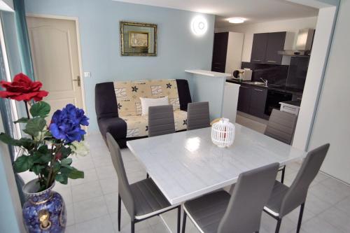 une table à manger et des chaises dans un salon dans l'établissement Modern apartment with terrace and beach 5 min away, à Fréjus