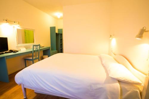 a bedroom with a bed and a desk with a mirror at Gray Manor Hotel in Andover