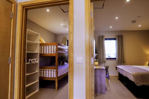 a bedroom with a bed and a bunk bed at Les Ormes Resort in St Brelade