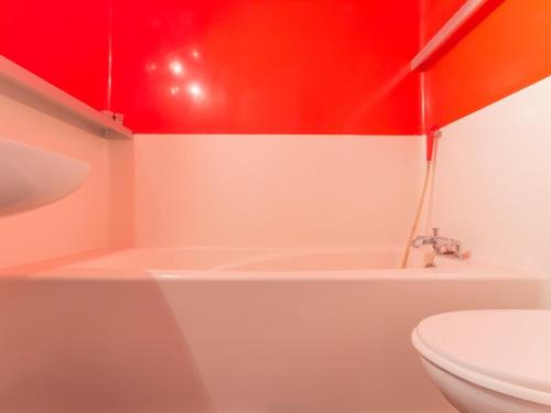La salle de bains est pourvue d'une baignoire blanche et d'un plafond rouge. dans l'établissement Studio cabine proche centre, balcon, 5 pers - FR-1-346-443, à Arc 1800