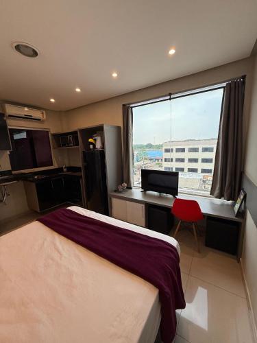 a bedroom with a bed and a desk and a window at Studio Maraba-LOFT LINDO in Marabá