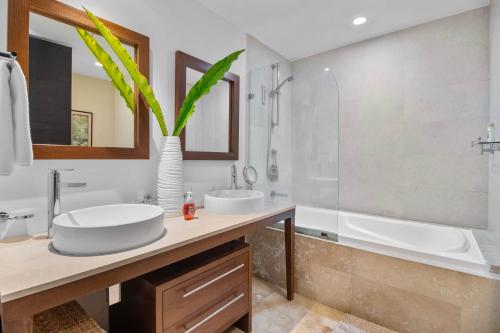 a bathroom with two sinks and a bath tub and a vase at Spectacular Apartment Ocean View Puerto Vallarta in Puerto Vallarta