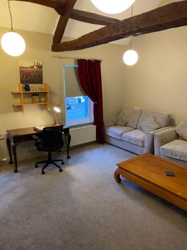 sala de estar con sofá, mesa y escritorio en Kezbah 1, 22 the square centre of Dalston village, en Carlisle