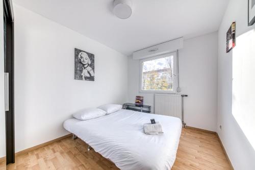 - une chambre avec un lit blanc dans une pièce dotée d'une fenêtre dans l'établissement GuestReady - Tranquil Escape in the City, à Lyon