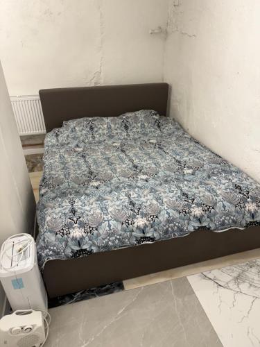 a bed in a room with a blue and white comforter at Eksporta apartments 5 in Rīga